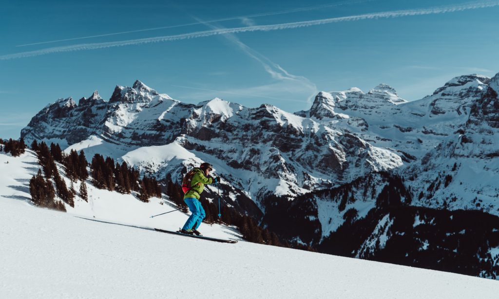 a man skiing on a sunny day with mountains in the background